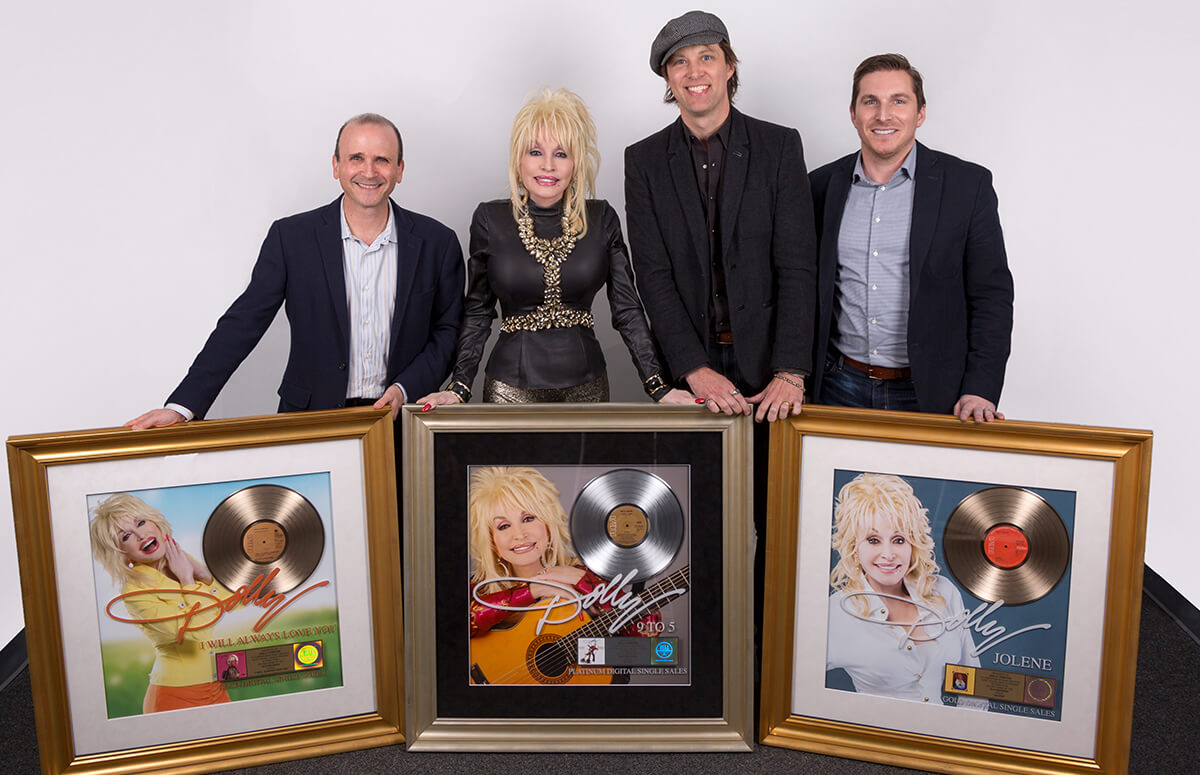 Dolly Parton was surprised with 3 RIAA certification plaques (left to right) are: Greg Linn, SVP, Marketing & Content, Legacy Recordings/Sony Music; Parton; John Jackson, SVP, A&R, Legacy Recordings/Sony Music; and John Zarling, EVP, Marketing & New Business, Sony Music Nashville. Photo credit: John Shearer